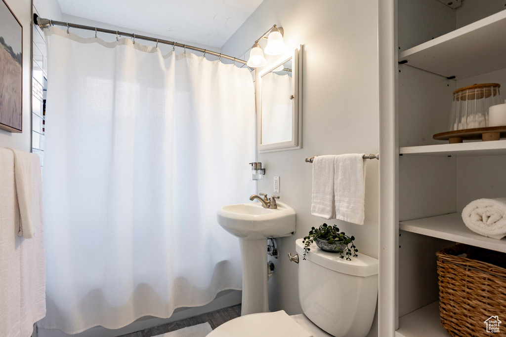 Full bathroom featuring toilet and shower / bathtub combination with curtain