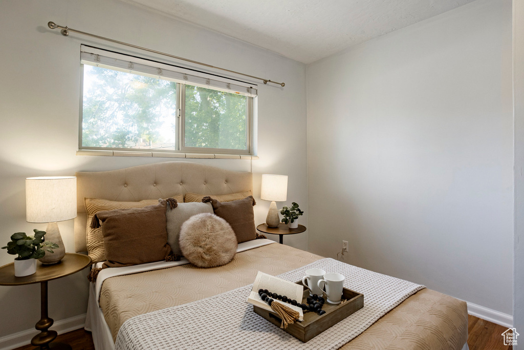 Bedroom with wood finished floors and baseboards