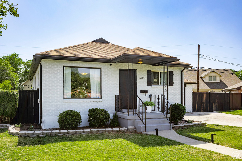 View of front of house with brick siding, concrete driveway, and roof with shingles