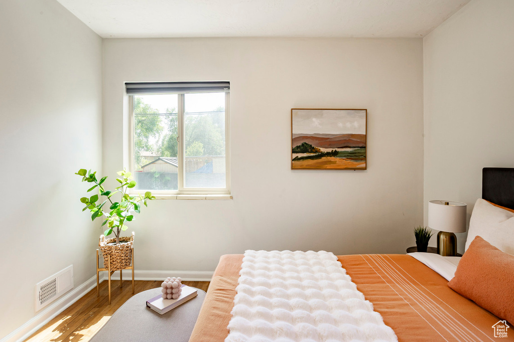 Bedroom with wood finished floors and baseboards