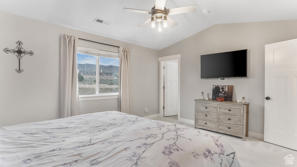 Bedroom featuring ceiling fan, light carpet, baseboards, lofted ceiling, and visible vents