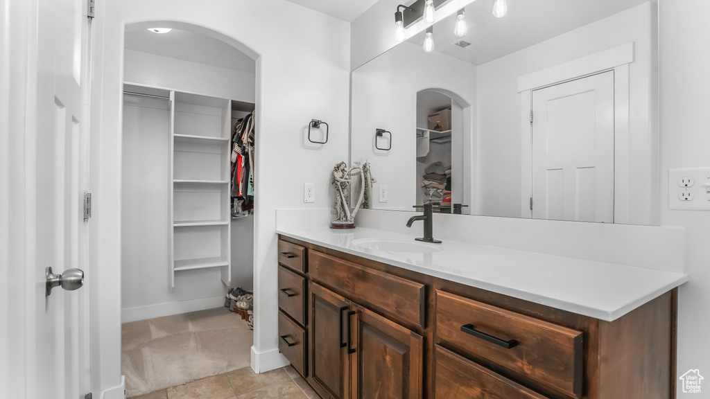 Bathroom featuring a walk in closet and vanity