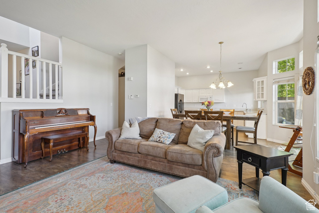 Living area with baseboards, recessed lighting, wood finished floors, and a chandelier