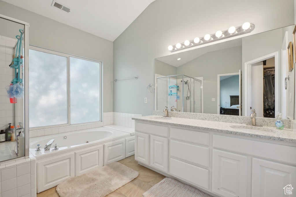 Full bath featuring a bath, visible vents, a shower stall, vaulted ceiling, and a sink