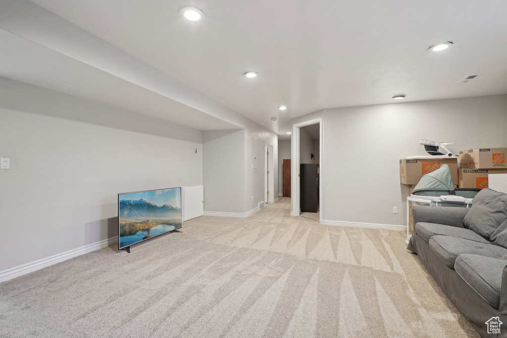 Living area featuring light colored carpet, recessed lighting, and baseboards
