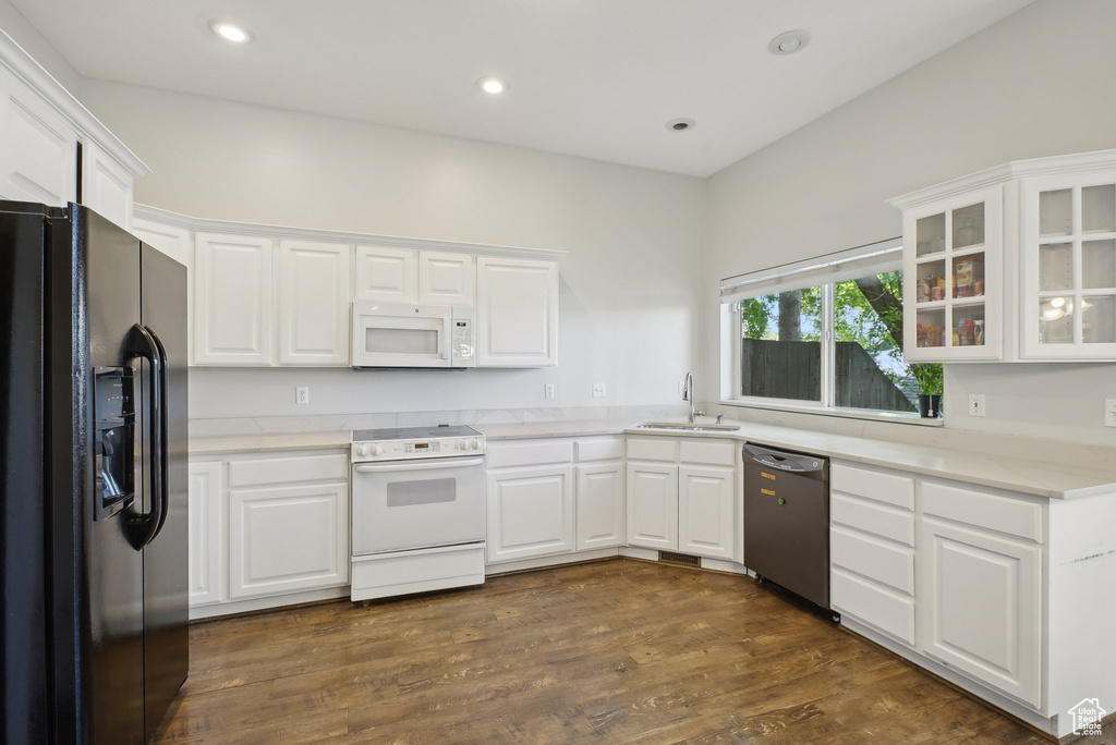 Kitchen featuring a sink, glass insert cabinets, white cabinets, and white appliances
