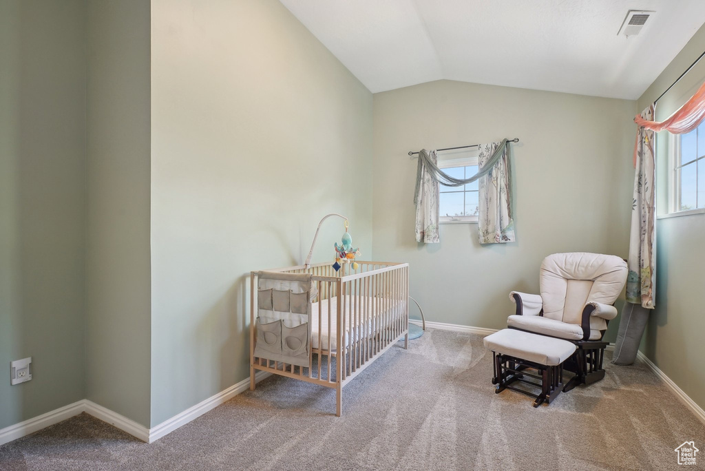 Bedroom featuring baseboards, multiple windows, a crib, and carpet