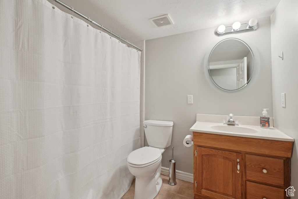 Bathroom with visible vents, tile patterned floors, baseboards, vanity, and toilet