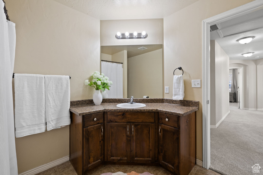 Full bathroom with visible vents, baseboards, and vanity