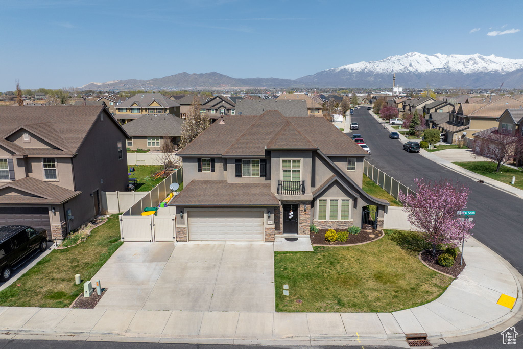 View of front facade featuring a gate, stone siding, a mountain view, stucco siding, and a residential view