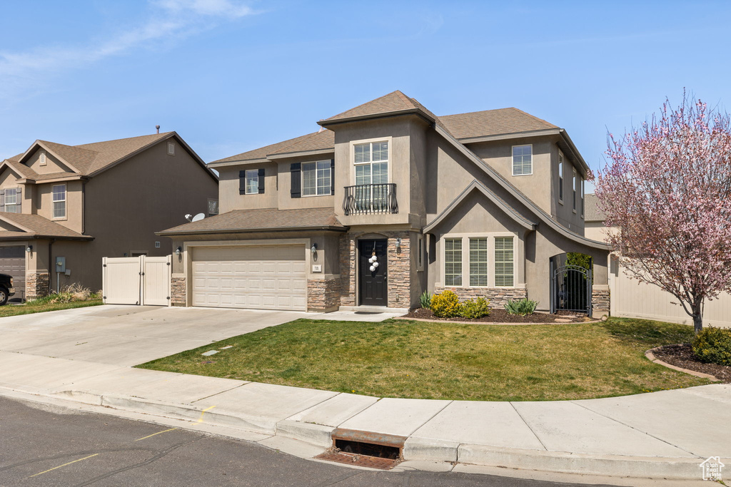 Traditional home featuring stone siding, a gate, and stucco siding