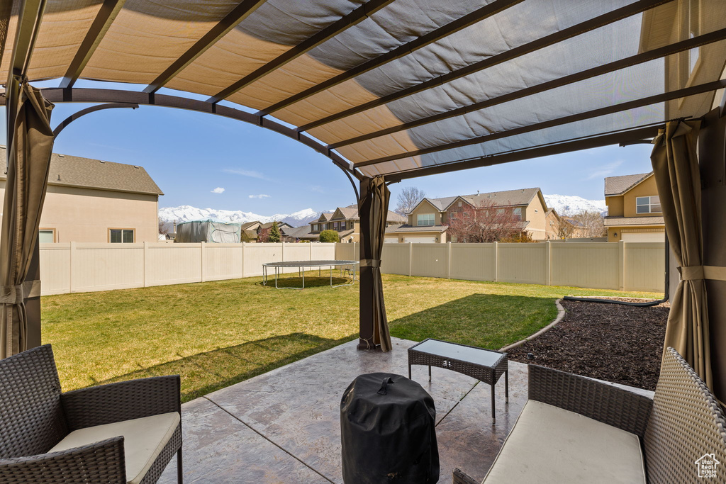 View of patio featuring a fenced backyard, a pergola, a trampoline, and area for grilling