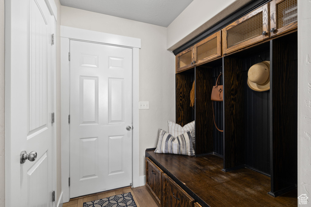 Mudroom featuring dark wood finished floors and baseboards