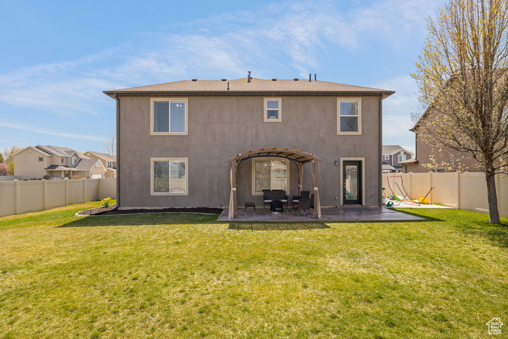 Back of house featuring a lawn, a fenced backyard, and a patio