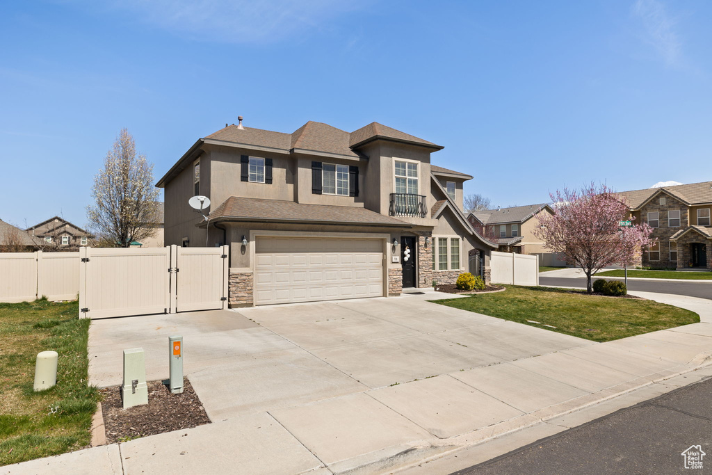 Traditional home with a gate, fence, concrete driveway, stucco siding, and stone siding