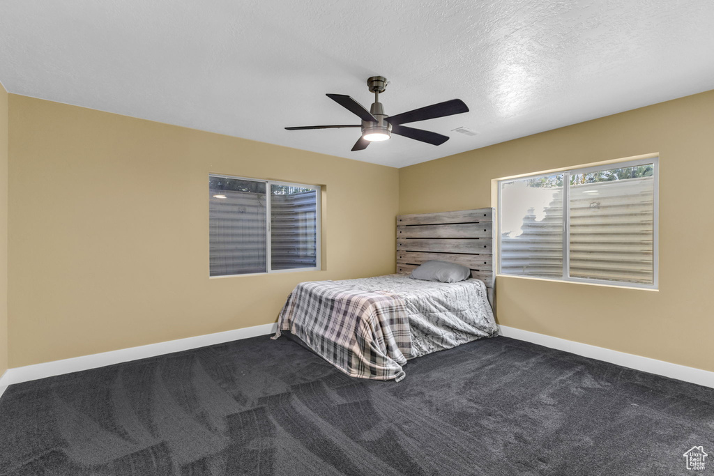 Bedroom featuring carpet floors, baseboards, and ceiling fan