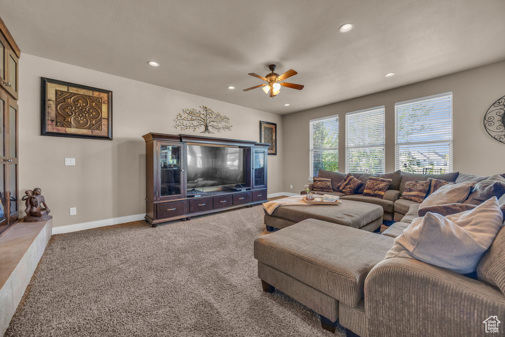 Carpeted living room with a ceiling fan, recessed lighting, and baseboards