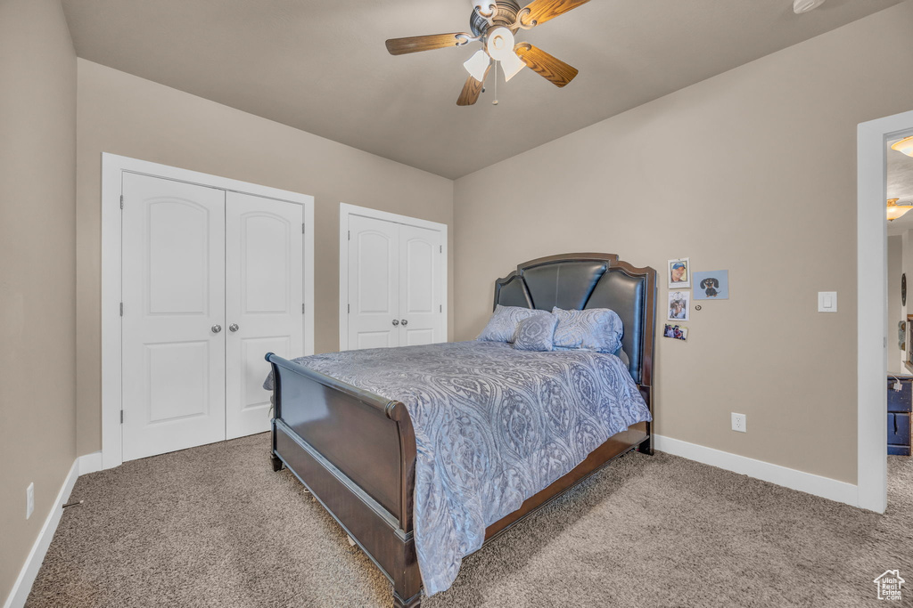 Bedroom with carpet, baseboards, and two closets