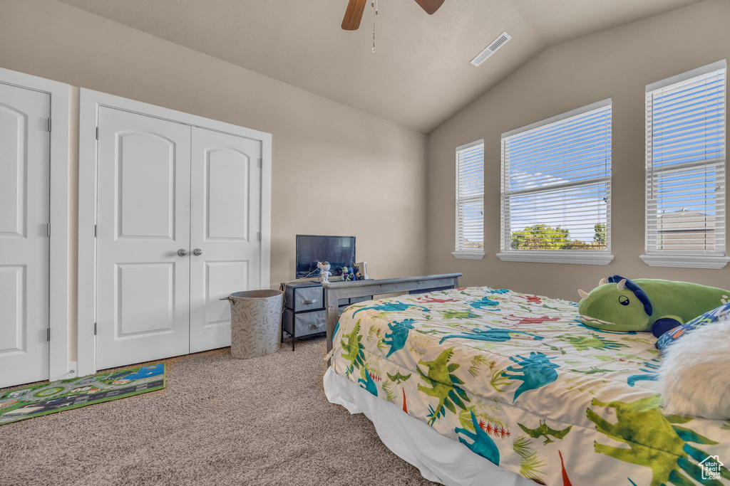 Bedroom featuring carpet flooring, vaulted ceiling, a closet, and a ceiling fan