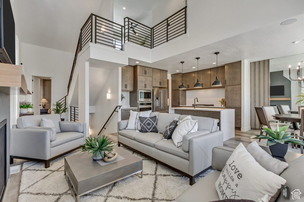 Living area featuring a towering ceiling, recessed lighting, and a notable chandelier