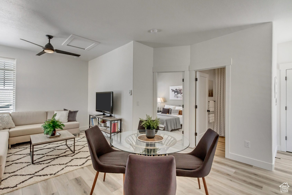 Dining room with attic access, ceiling fan, baseboards, and light wood-style flooring