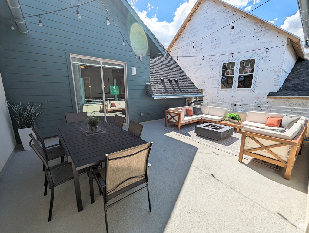 View of patio with an outdoor living space with a fire pit and outdoor dining space