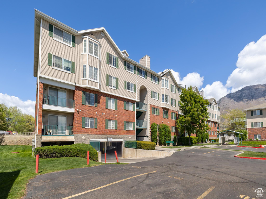 View of property with a mountain view and uncovered parking