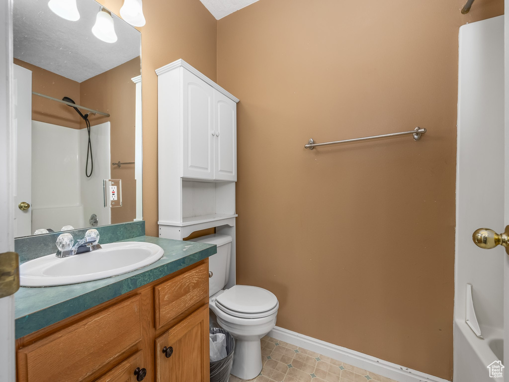 Full bath featuring walk in shower, baseboards, tile patterned floors, vanity, and toilet