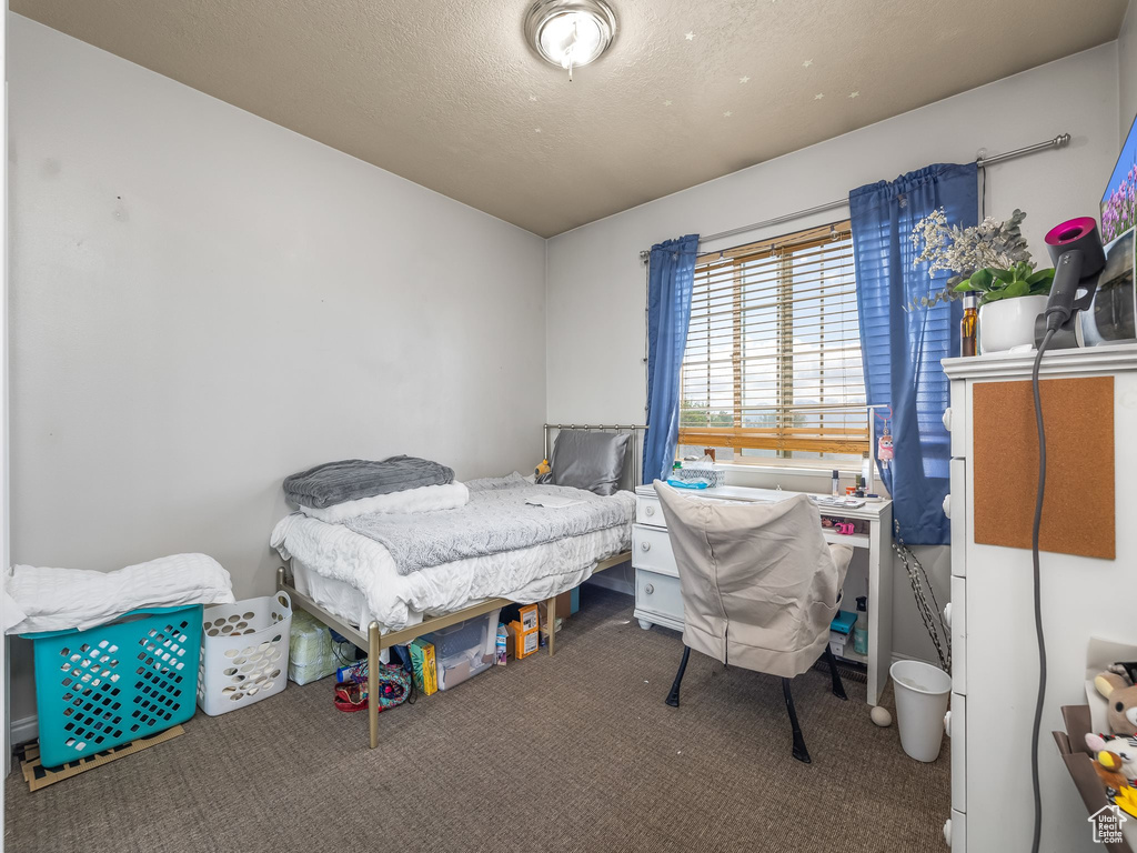 Bedroom featuring a textured ceiling and carpet