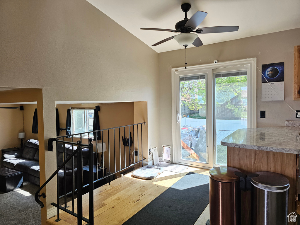 Dining room with wood finished floors, ceiling fan, and vaulted ceiling