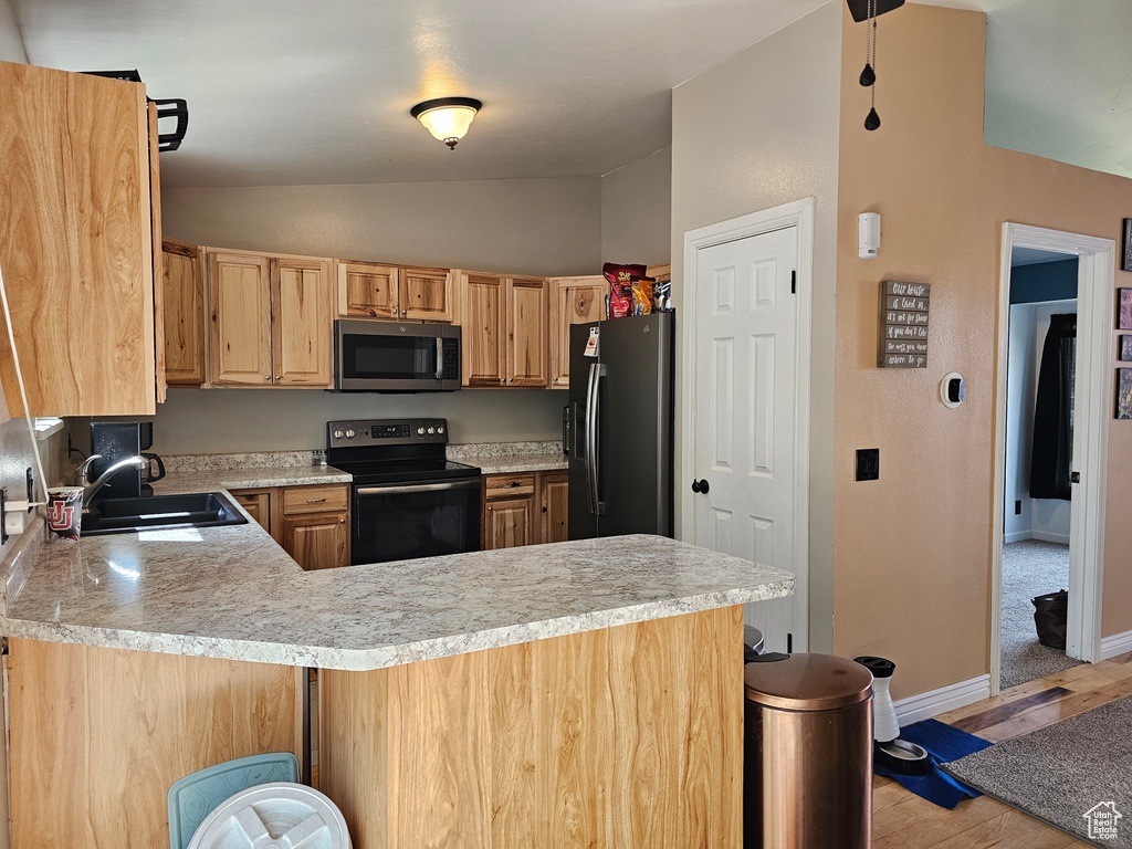 Kitchen with lofted ceiling, stainless steel microwave, a sink, black / electric stove, and refrigerator with ice dispenser