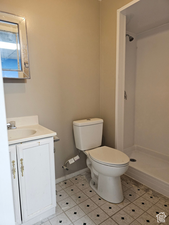 Bathroom with a shower stall, toilet, vanity, and tile patterned floors