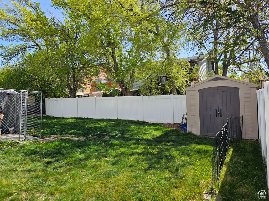 View of yard with a storage shed, a fenced backyard, and an outdoor structure