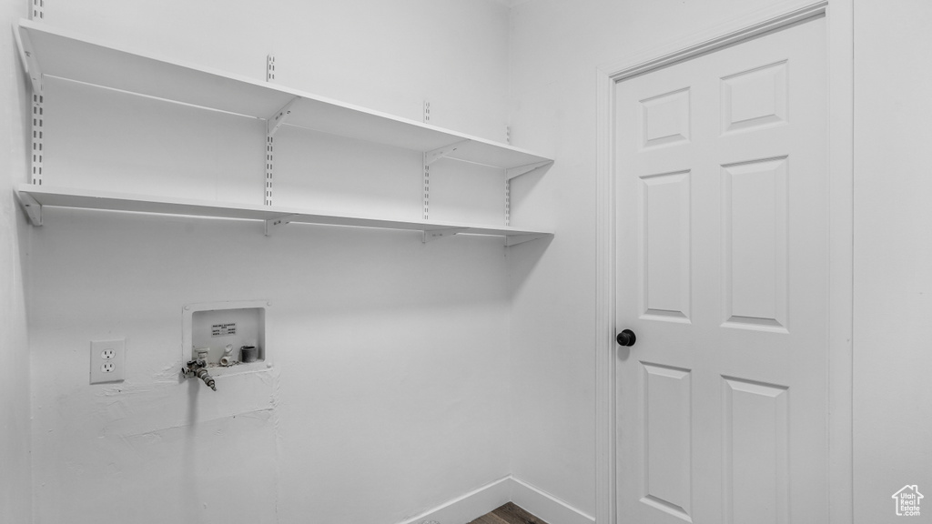 Clothes washing area with baseboards, hookup for a washing machine, and laundry area