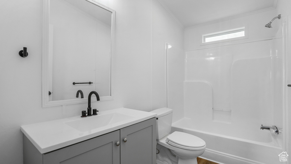 Full bath with shower / bathing tub combination, toilet, vanity, and ornamental molding