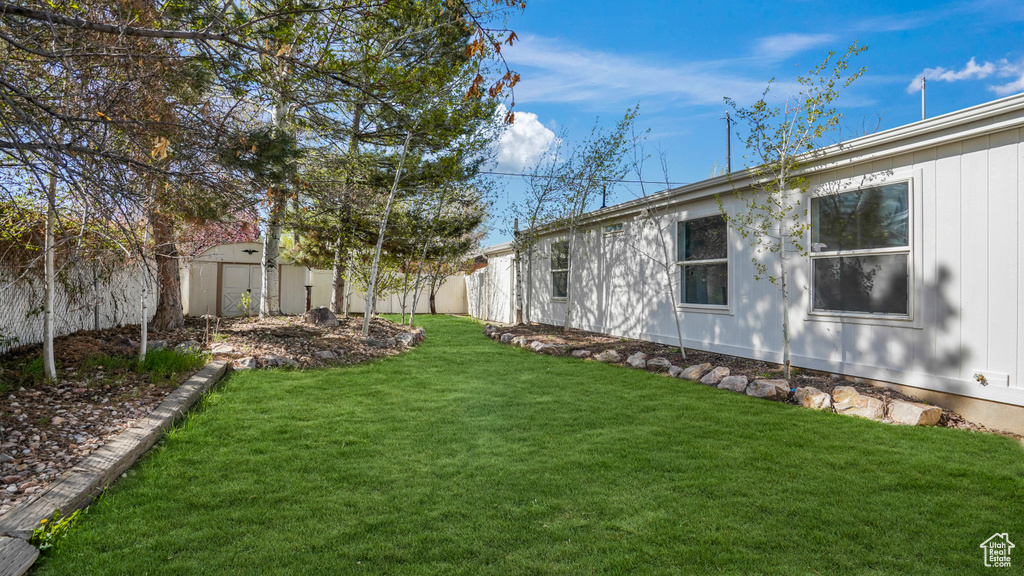 View of yard featuring a fenced backyard, an outbuilding, and a storage shed