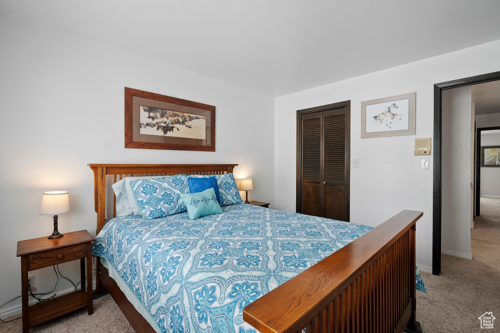 Carpeted bedroom featuring a closet and baseboards