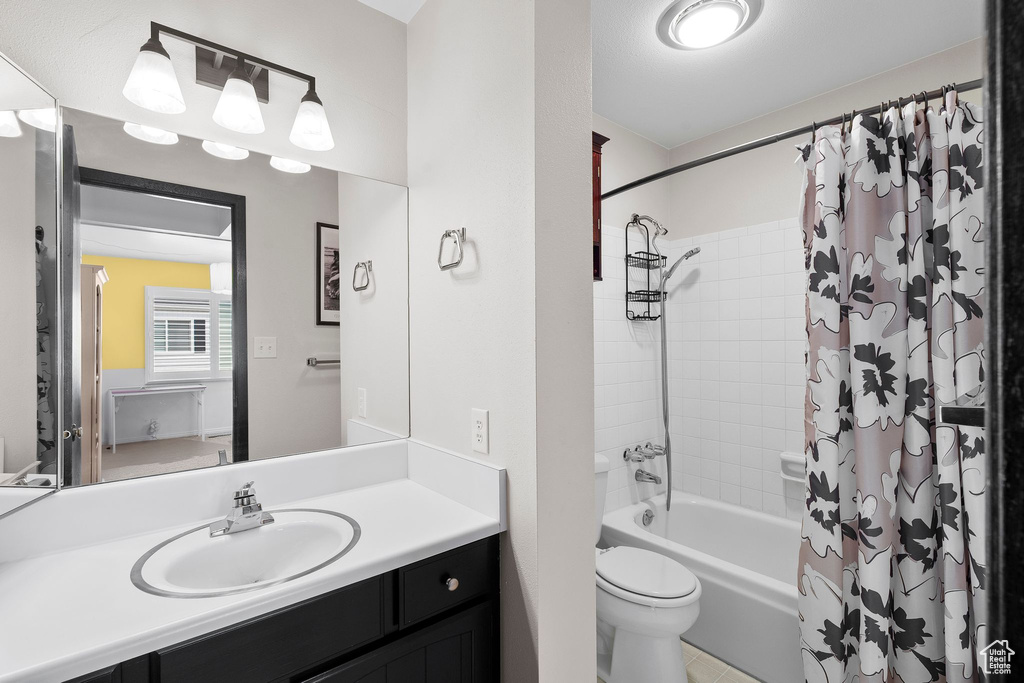 Full bath featuring shower / bath combo with shower curtain, toilet, and vanity