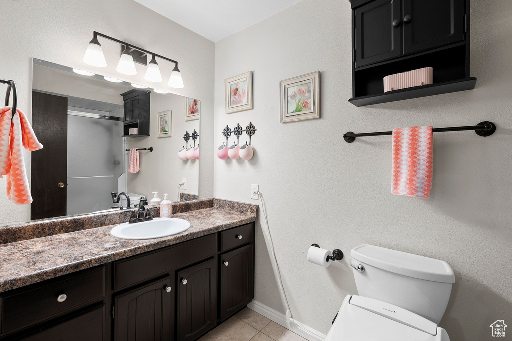 Full bathroom featuring tile patterned floors, baseboards, vanity, and toilet