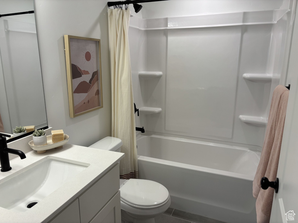 Bathroom featuring shower / bath combo, vanity, and toilet