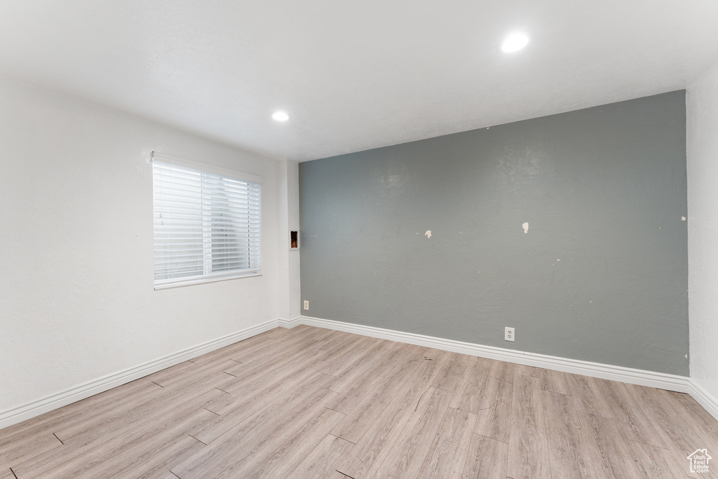 Unfurnished room with light wood-style flooring, baseboards, and recessed lighting