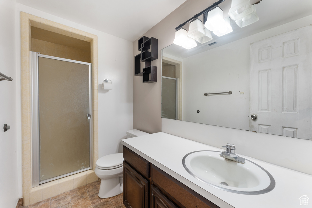 Full bathroom with a shower stall, toilet, and vanity