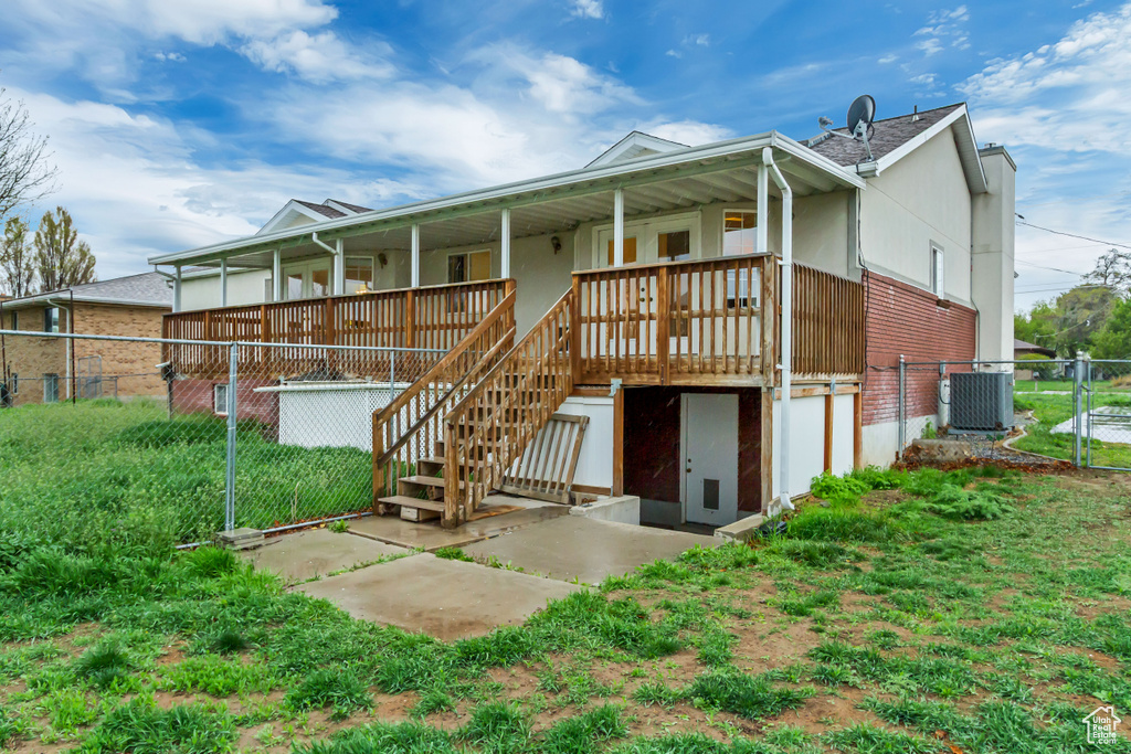 Back of property with central air condition unit, fence, a porch, and stairs