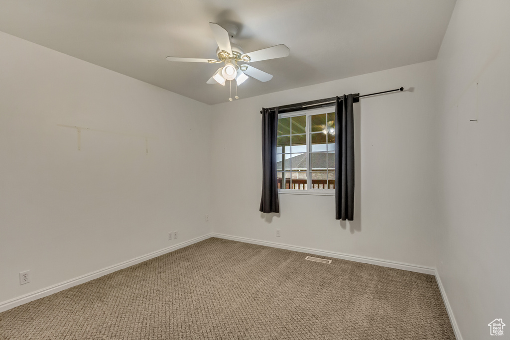 Empty room with carpet floors, baseboards, and ceiling fan