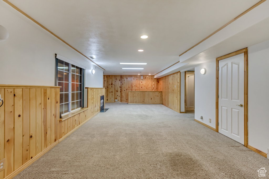 Finished basement featuring recessed lighting, carpet flooring, wood walls, and baseboards