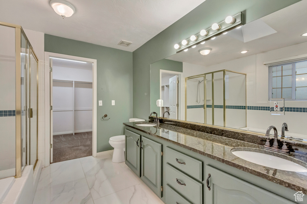 Full bathroom featuring a shower stall, marble finish floor, and a sink