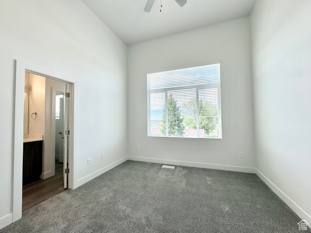 Carpeted empty room featuring a ceiling fan, baseboards, a healthy amount of sunlight, and visible vents