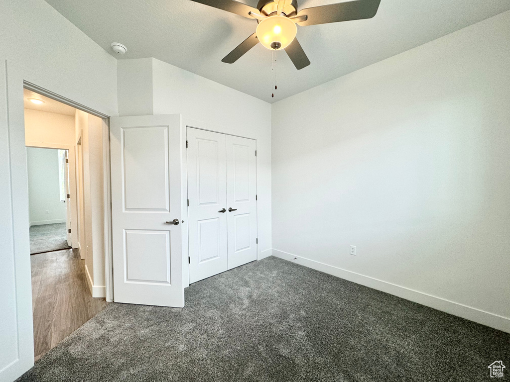 Unfurnished bedroom with baseboards, carpet flooring, a closet, and ceiling fan