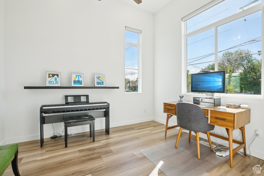 Office area with baseboards, wood finished floors, and a healthy amount of sunlight