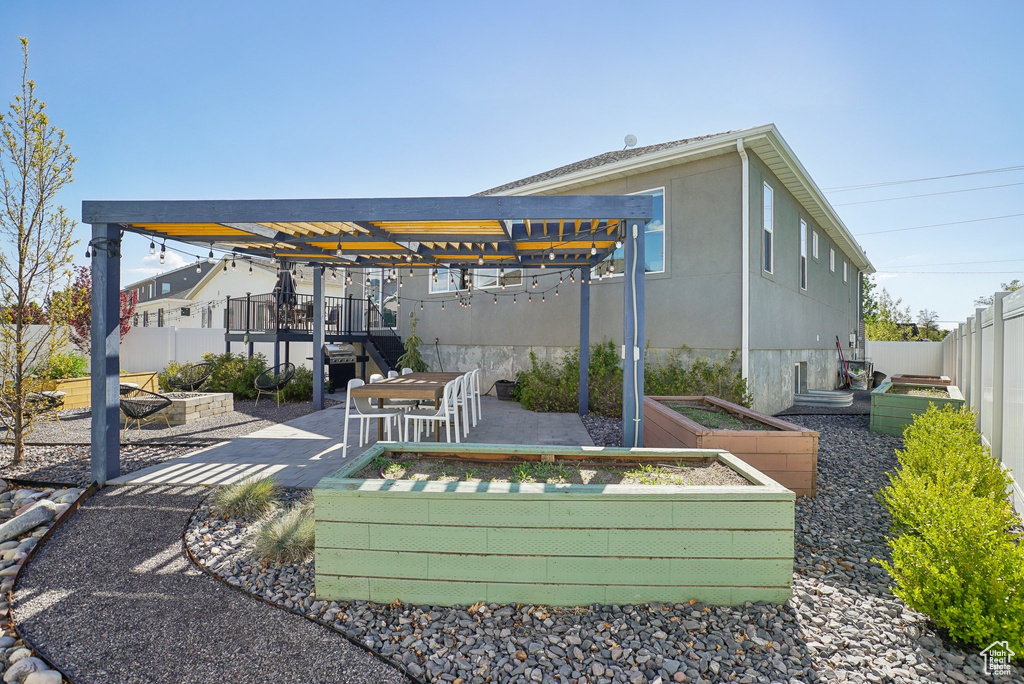View of property\\\'s community featuring a garden, a fenced backyard, and a patio area